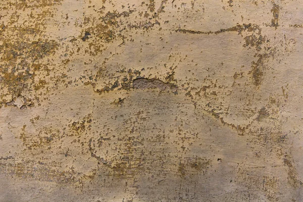 Régi vakolt fal repedésekkel. Egy antik épület okker színű, ősi vakolt fala. Régi stukkó textúra. Közelkép. — Stock Fotó