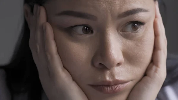 Femme épuisée médecin ressent du stress ou des maux de tête. Pensive asiatique surmené femme serré sa tête dans ses bras regardant vers le côté — Photo