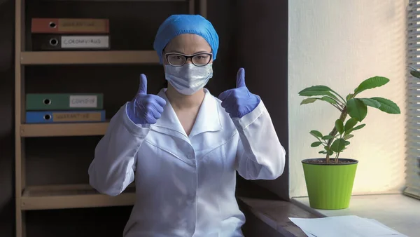 Medicul pozitiv arată încurajatoare Da gest. Degete în sus gest de la lucrător medical de sex feminin pe fundalul unui interior spital — Fotografie, imagine de stoc