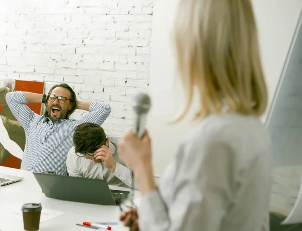 Longo discurso de mulher de negócios cansada de ouvintes masculinos. Concentre-se em bocejar homens entediados sentados na mesa do escritório ao fundo. Conceito de conferência. Imagem tonificada — Fotografia de Stock