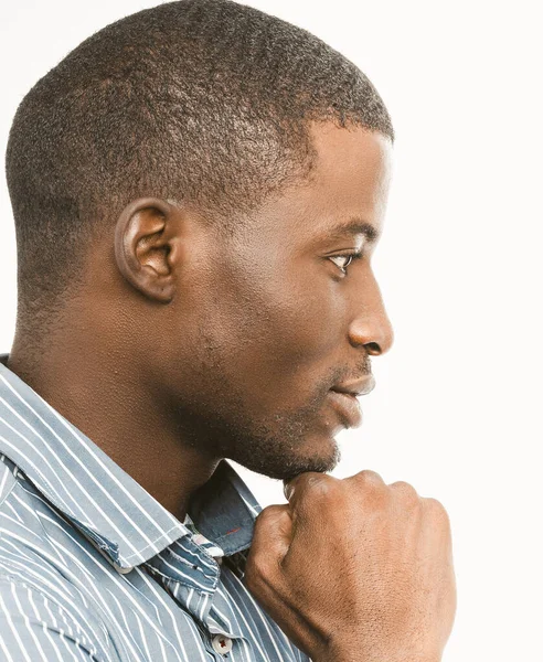 Figyelmes afro-amerikai férfi megérinti az állát, oldalra néz. Profilkép rövid hajú jóképű fickóról fehér háttérrel. Közelkép portré. Tonozott kép — Stock Fotó