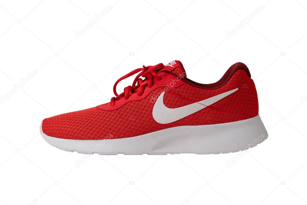 Red sneakers of Nike brand. Shoes with laces for jogging and fitness. Stylish youth model. Object cut out on white background. Side view. May, 2019. Kiev, Ukraine.