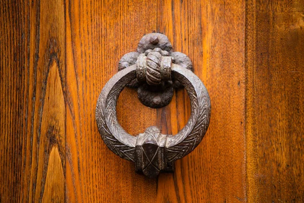 Antik rund metall handtag på en trä ytterdörr. Vacker brun färg elegant entré handtag på dörren. Vintage metall objekt isolerad på trä bakgrund. Närbild skott. Framifrån — Stockfoto
