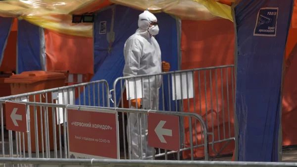 Médico en traje de protección epidemiológica. Corredor rojo de mayor grado de peligro. Concéntrate en la placa roja en primer plano. Centro de contracción covid-19. Hospital Municipal. mayo, 2020, Brovary, Ucrania —  Fotos de Stock