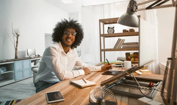 Un jeune homme d'affaires travaille chez lui. Creative Arab millennial regarde la caméra assise sur le lieu de travail à la maison avec un ordinateur laotop dessus. Image tonique — Photo