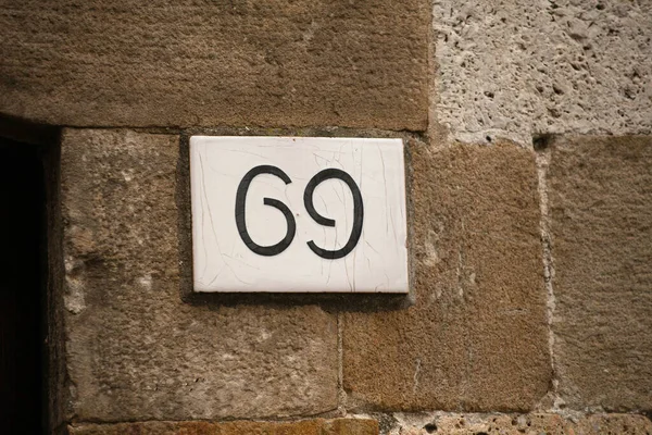 レンガの古い壁に家の番号。古代の建物の壁にセクシーな69ライセンスプレート。陰陽の概念 — ストック写真