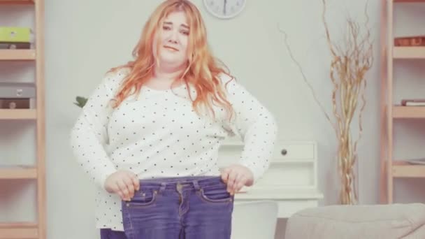 太りすぎの女の子は、彼女の特大の問題を示す栄養士にジーンズの彼女の古いペアをもたらし、健康上の問題についての相談.健康食品の概念。ティンテッドビデオ。第四百二十二条 — ストック動画