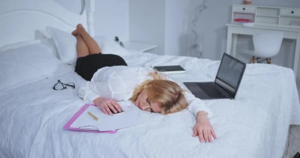 Alvó szabadúszó nő, aki késő este dolgozott a laptopon és a dokumentumokon. Egy nő, aki hosszú út után kiöltözve alszik. Üzleti koncepció. Gyümölcsfélék — Stock videók
