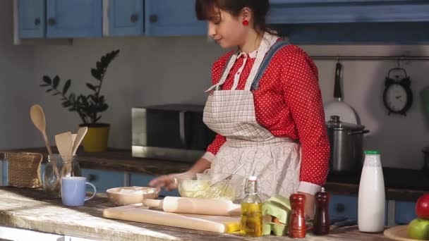 Dziewczyna gotuje w zabytkowej kuchni, próbując sobie przypomnieć, co robić dalej. Bierze mąkę, która rozwija się z chmurą i przyprawia ją. Widok z boku. Prores 422 — Wideo stockowe