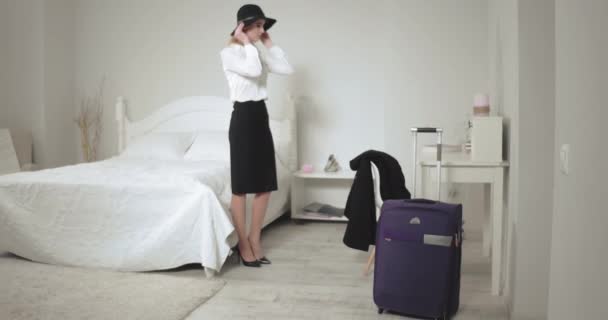 Kvinna i svart hatt går ut hotellrum med resväska cary bakom och rock i handen. Affärsresa fortsatte frilansare kvinna flyttar till olika städer och. Affärsidé. Prores 422 — Stockvideo