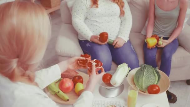Διατροφολόγος που δίνει φρούτα και λαχανικά κομμένα από ρόδι. Γιατρός μιλάμε για το πρόβλημα του βάρους και συμβουλεύει για θέματα υγείας. Υγιεινή διατροφή. Βαμμένο βίντεο. Πρότυπα 422 — Αρχείο Βίντεο