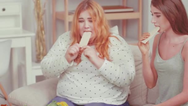 Κλείσε. Βουλιμική και υπέρβαρη κοπέλα που δοκιμάζει ψωμάκια. Γιατρός μιλάει για το πρόβλημα βάρους και συμβουλεύει για θέματα υγείας με τα κορίτσια φίλους της. Υγιεινή διατροφή. Βαμμένο βίντεο. Πρότυπα 422 — Αρχείο Βίντεο