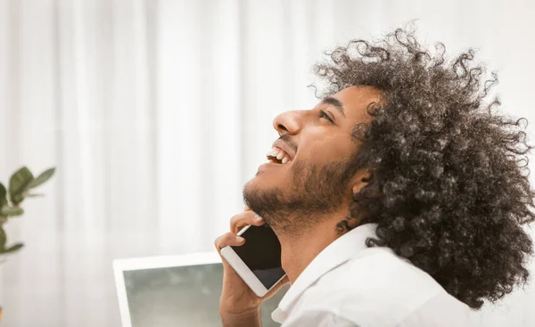 El hombre feliz sonríe ampliamente hablando de teléfono móvil sobre fondo blanco. Vista del perfil del guapo árabe hablando por teléfono. Cierre el retrato. Imagen teñida —  Fotos de Stock