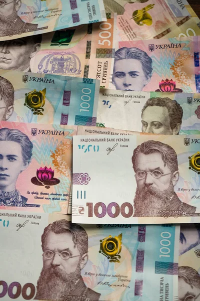 Ukraiński wzór pieniądza z nowego banknotu. Papierowe hrywny o różnej wartości nominalnej z 1000 hrywien na górze. Tło lub faktura. Format pionowy — Zdjęcie stockowe