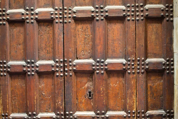 Puerta de madera antigua con remaches metálicos y cerradura. Primer plano. Estructura de malla de madera de broun envejecido. Textura o fondo —  Fotos de Stock