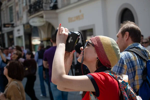 Kobieta turysta sprawia, że zdjęcie atrakcji na ulicy wśród tłumu. Kwiecień 2013. Wiedeń, Austria — Zdjęcie stockowe
