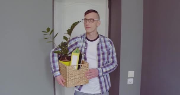 Ein Student betritt ein Studentenwohnheim und bringt seine persönlichen Sachen mit schönen Blumen in einer Schublade mit. Zufriedene junge studentische Freiberuflerin ist glücklich. Prores 422 — Stockvideo