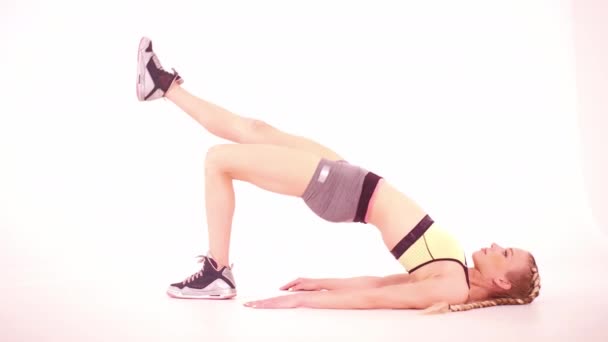 Fitness fille faisant pont glut avec jambe vue latérale. Tutoriels vidéo de sport isolés sur blanc. Concept de soins de santé. Concept sportif. des images teintées. Prores 422 — Video