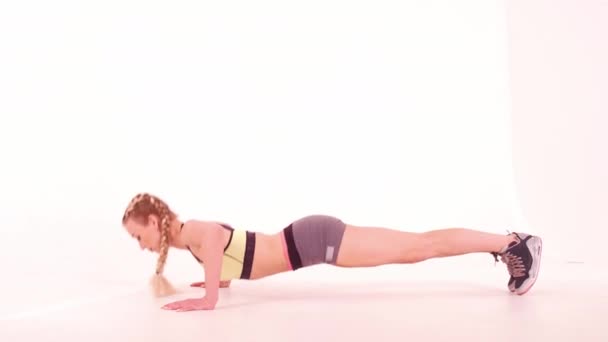 Γυμναστήριο κορίτσι κάνει push ups πλευρά πλήρη θέα του σώματος. Αθλητικά βίντεο tutorials απομονώνονται σε λευκό. Η έννοια της υγειονομικής περίθαλψης. Αθλητική ιδέα. φιμέ βίντεο. Πρότυπα 422 — Αρχείο Βίντεο