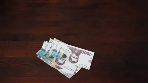 Man take away hands of pack of Ukrainian banknotes. New paper hryvnias different face value are on a brown wooden table. Cash money concept. prores 422 — Stock Video