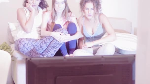 Beste Freundinnen, die im Pyjama Gruselfilme gucken und übernachten. Drei attraktive Mädchen, die sich glücklich umarmen. Freizeit genießen. Tonaufnahmen. Prores 422 — Stockvideo