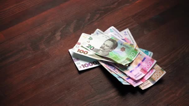 Új bankjegyek az asztalon. Új pénz bevezetése az ukrán nemzeti banktól fából készült asztali háttérrel. Készpénz koncepció. Befektetési koncepció. Közelről. Gyümölcsfélék — Stock videók