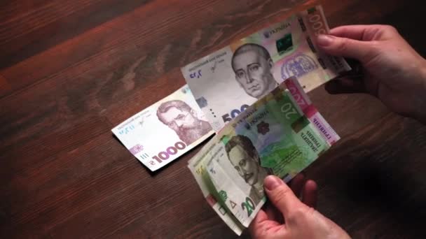 Un nouveau billet dans la vie quotidienne de la banque nationale ukrainienne. Mains masculines comptant le nouveau papier-monnaie ukrainien. Copiez l'espace à droite. Concept de paiement. Prores 422 — Video