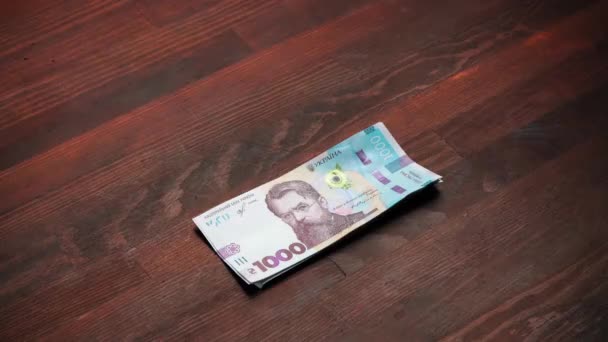 Pak Oekraïense van duizendste biljetten bankbiljetten. Nieuw papier hryvnias verschillende nominale waarde zijn op een bruine houten tafel. Contant geld concept. Prores 422 — Stockvideo