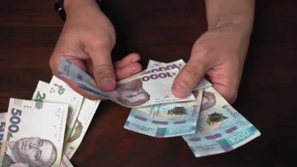 Concept d'investissement. Nouvelle monnaie de papier ukrainienne entre les mains des hommes. Homme riche considérant les billets en papier dans les dénominations de 1000 hryvnias. Prores 422 — Video