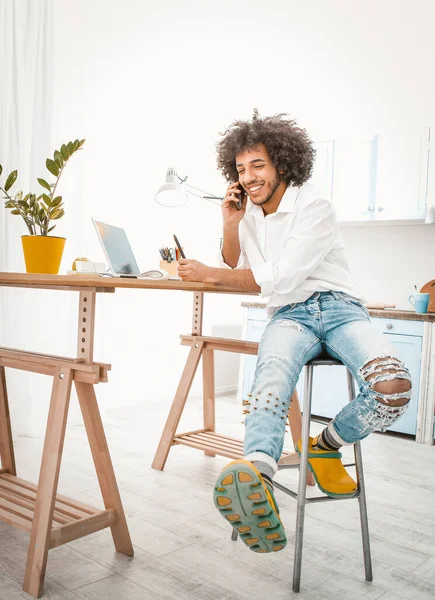 Hombre alegre descansa charlando por teléfono móvil. Un joven inteligente hablando con un compañero de casa. Concepto de cuarentena. Imagen teñida — Foto de Stock