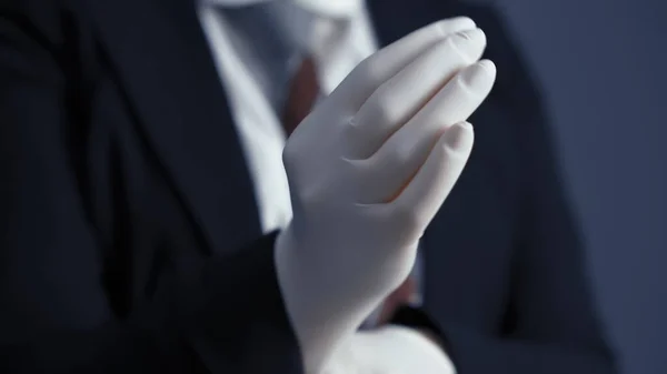 İş adamı tek kullanımlık beyaz eldivenler giyer. Karantina sırasında ve sonrasında iş. Yakın çekim. — Stok fotoğraf
