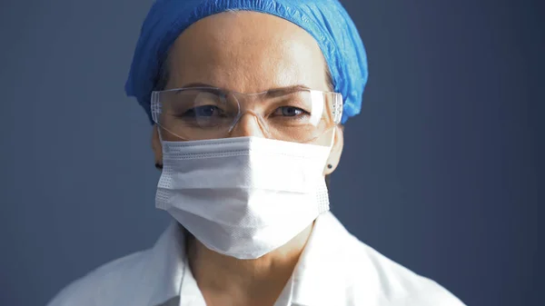 Médica madura em máscara e óculos retrato. Mulher caucasiana, médica de laboratório de costas cinzentas. Fechar tiro — Fotografia de Stock