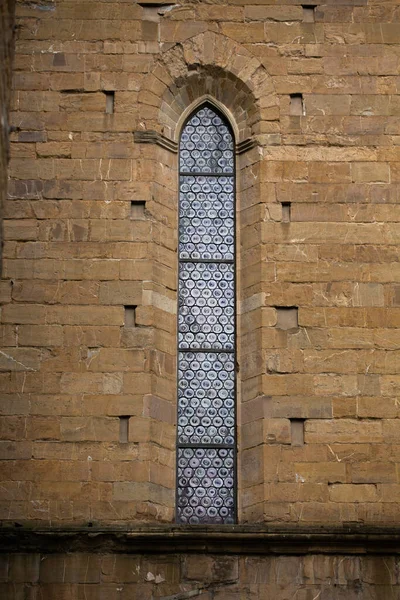 古砖建筑竖直窄窗中的旧彩色玻璃窗。大教堂。May, 2013.意大利比萨 — 图库照片
