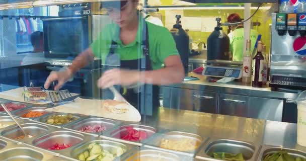 Restaurant worker wraps sandwich in to a paper to sere it to a customer. Take away food concept. Food on the go. Fresh Line, September 2017, Kiev, Ukraine. Prores 422 — Stock Video