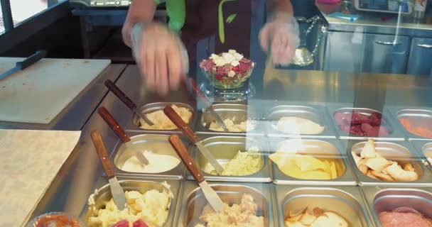 Salad bar. woman add a spoon of sous. Waitress making a salad to a costumer adding all ingredients he asking. Fresh line restaurant. September 2017. Kiev Ukraine. Prores 422 — Stock Video