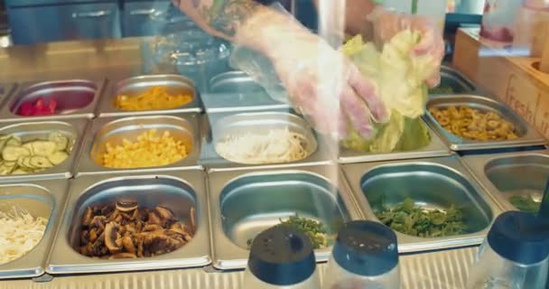 Zaměstnanec restaurace přidá na požádání do talíře zelí se salátovými ingrediencemi. Fresh Line, září 2017, Kyjev, Ukrajina. Prores 422. — Stock video