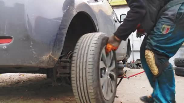 Man haalt het stuur van Nissan Leaf met behulp van een hogedrukhamer. Auto monteur balanceren auto wiel machine balancer in auto reparatie service. november 2017. Kiev, Oekraïne. Prores 422 — Stockvideo