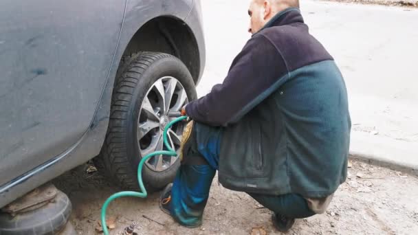 Nissan Leaf Nulové emise, Profesionální automechanik pomocí zásuvky momentového klíče a nástavce na matice tažné matice automobilového kola. Listopad 2017. Kyjev, Ukrajina. Prores 422 — Stock video