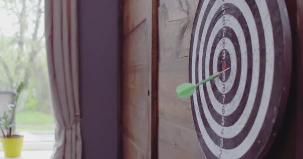 Man throwing dart in to a dart board hanging on classical wooden wall scoring nine. Dartboard in home interior. Toned footage. Prores 422 — Stock Video