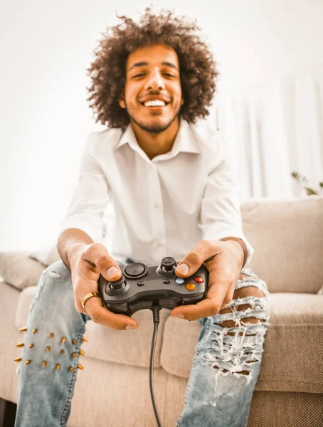 Jogador engraçado jogar jogos de computador sentado sozinho em casa em auto-isolamento durante o período de quarentena. Jovem árabe tem joystick ou gamepad. Concentre-se em mãos masculinas em primeiro plano. Imagem matizada — Fotografia de Stock