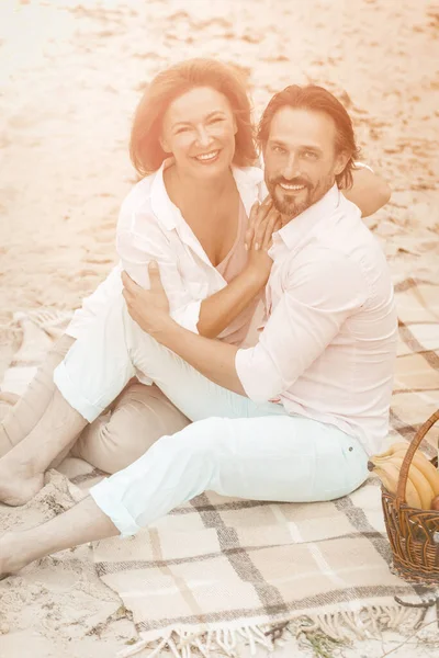 Handsome couple hug resting at sand beach together. appy Caucasian man and woman looks at camera. Tinted image — Stock Photo, Image