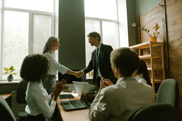A vezetők kézfogása a kollégák tapsának. Üzletemberek kezet ráznak egymással. Csapatmunka az irodában. Tonozott kép — Stock Fotó