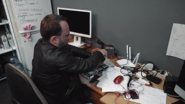 Мужчина средних лет купил жесткое программное обеспечение для обновления своего компьютера. Специалист по ремонту компьютеров собирает новую материнскую плату для компьютера из приобретенных деталей. Май 2019 года, Киев, Украина. Прорес 422 — стоковое видео