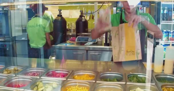 Pracownik restauracji Fast food pakujący świeżo zrobione kanapki do papierowej torby na życzenie. Fresh Line, wrzesień 2017, Kijów, Ukraina. Prores 422 — Wideo stockowe