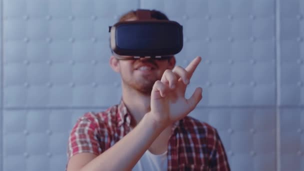 Moderne teknologi. Guy touch virtuel bog aflæse det med fingeren ved hjælp af moderne vr briller indendørs. Smuk teenager fyr iført virtual reality headset forsøger at justere virkeligheden. Prores 422 – Stock-video