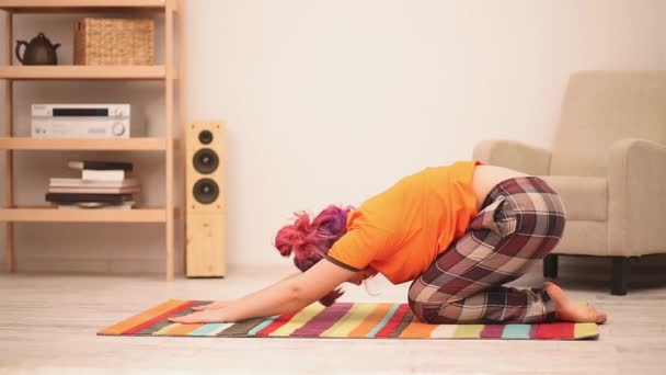 Chica sentada en el suelo realizando ejercicio de estiramiento de yoga en pose de cachorro luego loto con las manos arriba. Concepto de sobrepeso. Concepto de comida saludable. Prores 422 — Vídeo de stock