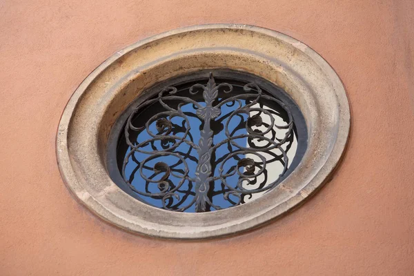 Antique round window with ornate metal bars on the plastered wall of old building. April 2013. Vienna, Austria — Stock Photo, Image