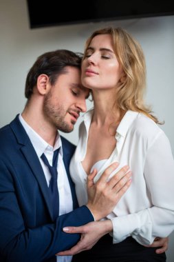 Business people closing eyes with pleasure while flirting in office. Man touching female body. Sexual enjoyment concept. Flirtation or sexual harassment at workplace clipart