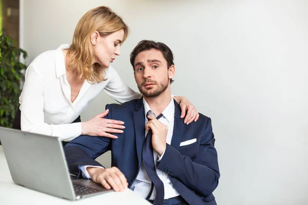 Blonde Chefin Geschäftsfrau verführt ihren männlichen Assistenten, der mit Laptop-Computer arbeitet.Verführung eines Untergebenen im Büro. Flirt oder sexuelle Belästigung — Stockfoto