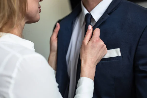 Kaukasische Frau richtet Geschäftsleuten den Kragen. Leidenschaftlich flirtende Geschäftsleute. Liebesaffäre im Amt. Nahaufnahme — Stockfoto